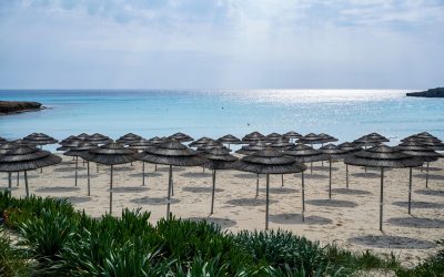Nissi beach in Ayia Napa full of reed umbrellas and Mediterranean sea in the background